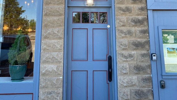 A building facade with a blue door labeled "Stay in Crozet" and a sign above indicating overnight lodging.