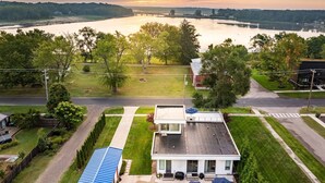 A house with a large front yard, a garage, and a patio area with umbrellas. - Douglas Modern Villa - Steps to Downtown! (Douglas)