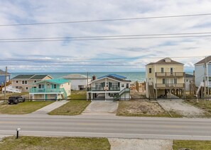 A coastal residential area with houses, a road, and a beach in the background. - Beaches B Tripp'n - Awesome 4 BR Home - Ocean View and Elevator! (North Topsail Beach)