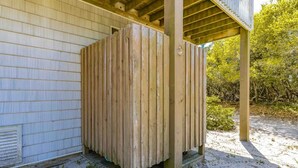 A wooden structure, possibly a sauna or outdoor shower, attached to a building with a wooden exterior.