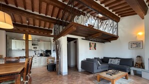 Un vaste espace de vie comprenant une table à manger, un canapé et un escalier.