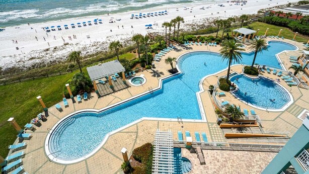Ein Resort mit mehreren Schwimmbecken, einem Strand und Blick auf den Ozean.