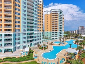 A multi-story hotel with balconies, a swimming pool, and a landscaped area.