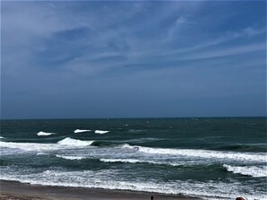 Ein Strand mit Wellen und blauem Himmel.