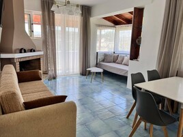 Una sala de estar moderna con un sofá, una mesa de comedor y una chimenea.