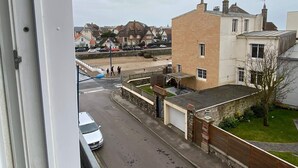 Une rue résidentielle bordée de maisons, avec une voiture garée et un passage piéton.