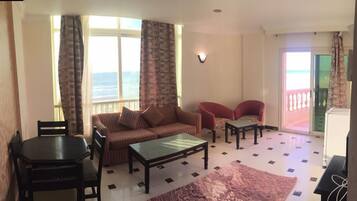 Deluxe Suite | Living room | 24-inch LCD TV with cable channels, TV