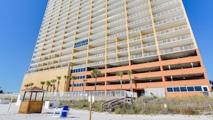 A multi-story hotel with a uniform exterior, featuring balconies on each floor and a parking garage below. - Tropic Winds 1402 (Beachfront) - Free BeachService!! (Panama City Beach)