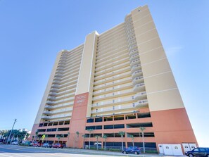 Un immeuble de grande hauteur doté de nombreux balcons et d’un garage.