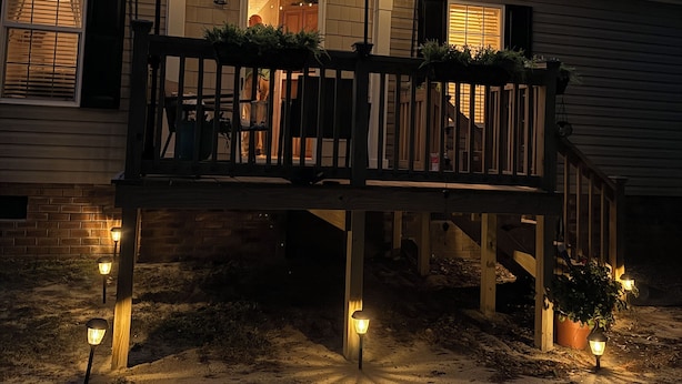 A house with a wooden deck, string lights, and a porch. - Great property for contract healthcare workers! (Hamlet)