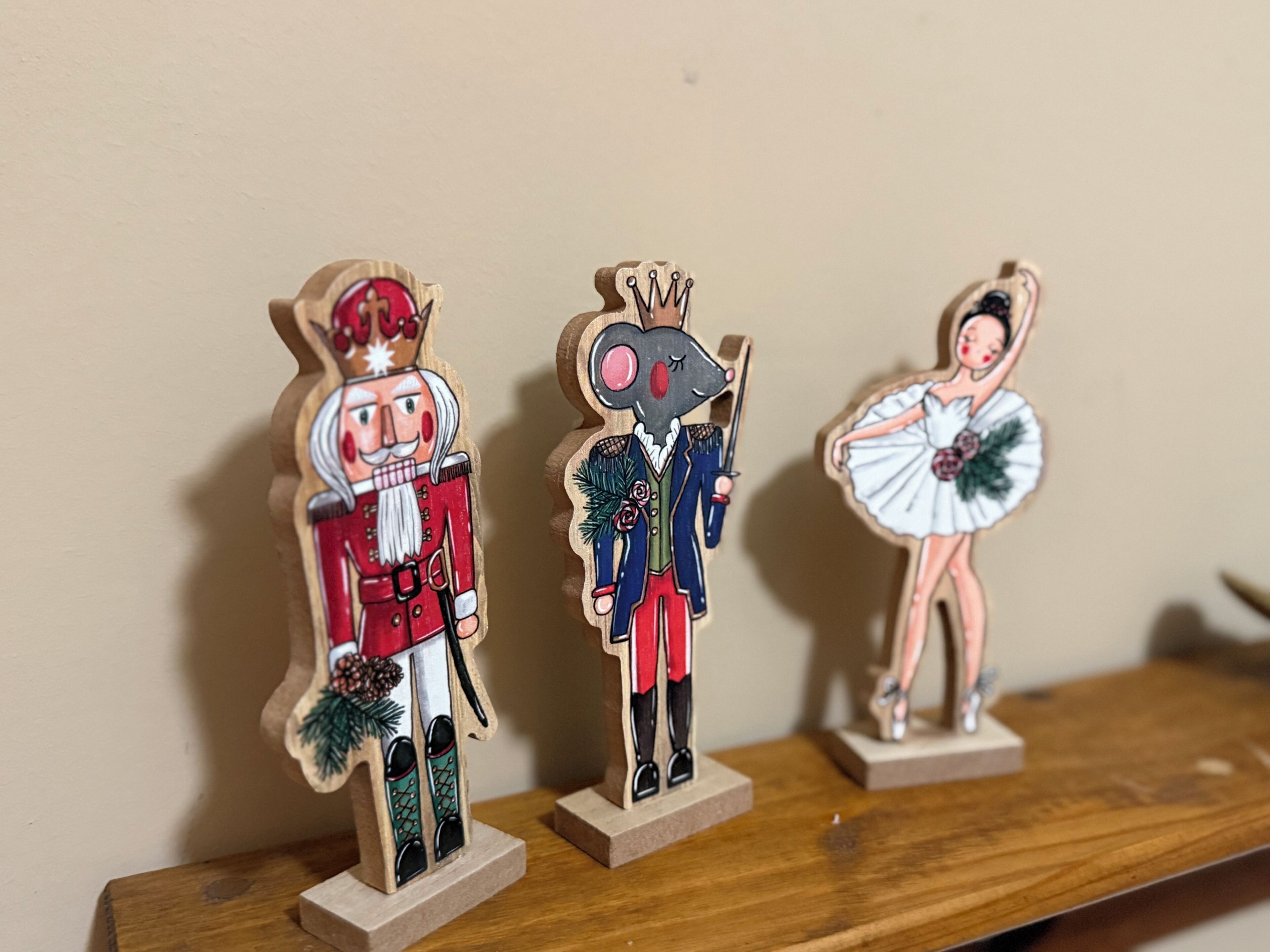 Trois figurines en bois représentant des casse-noisettes, posées sur une étagère.