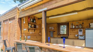 A rustic bar area with wooden walls, a counter, and bar stools. - 4 bedroom accommodation in Hogsthorpe, near Skegness (Hogsthorpe, near Skegness)