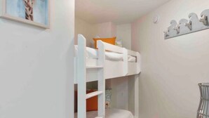A narrow room with bunk beds, a painting of a giraffe, and a small desk with a lamp. - Ground floor easy access! A127 (Fort Walton Beach)