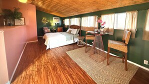 Une chambre à coucher avec un lit, un bureau, une chaise et une fenêtre.