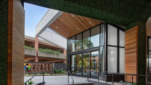 A modern Hyatt Place building with a glass facade, wooden accents, and a landscaped entrance. - Hyatt Place Atlanta / Perimeter Center (Atlanta)