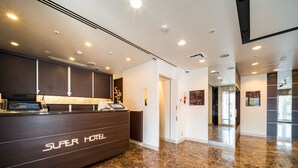 A hotel reception area with a marble floor, a reception desk labeled "Super Hotel," and a clear view of the lobby. - Super Hotel Ube Kosan Street (Ube)