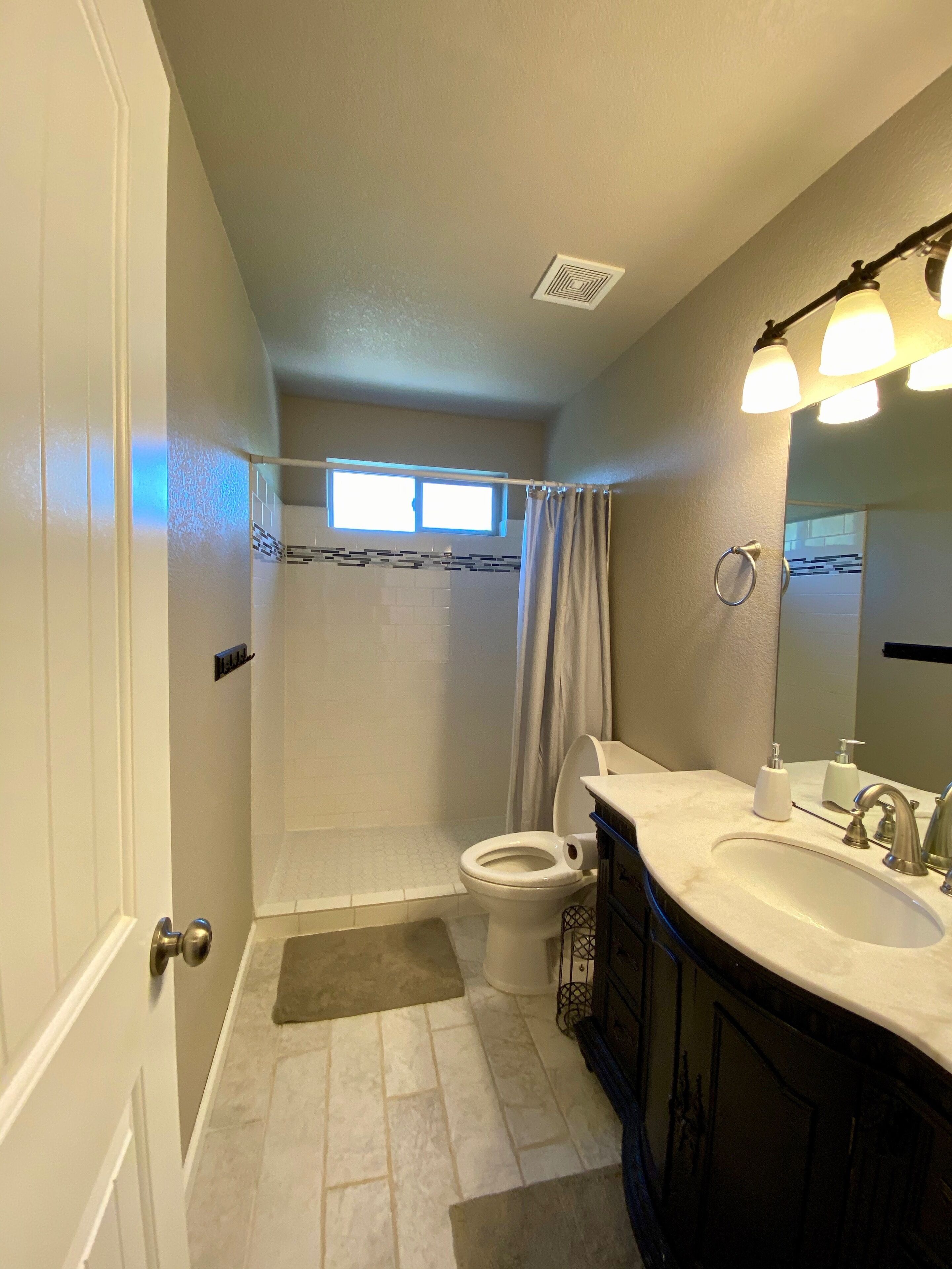 A bathroom with a shower, toilet, and sink.