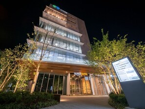 A multi-story hotel with a modern design, featuring a prominent 'Super Hotel' sign at the entrance.