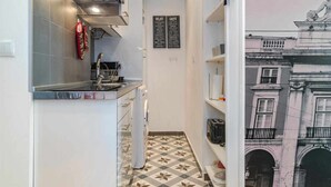 Una cocina estrecha con salpicadero de azulejos, horno empotrado y un panel de menú colgado en la pared.