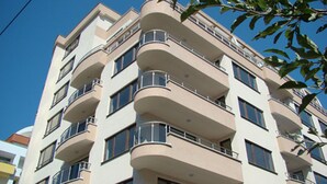 A multi-story residential building with balconies, large windows, and a clear blue sky in the background. - Luxury Apartment Venice - 1 (Sofia)