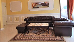 A living room with a sectional sofa, a coffee table, and a patterned rug. - Luxury Apartment Venice - 1 (Sofia)
