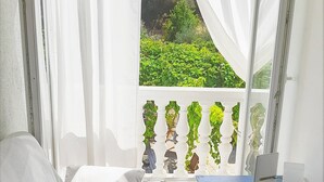Ein Schlafzimmer mit einem Bett, Kissen, einem Tisch und einem Laptop.