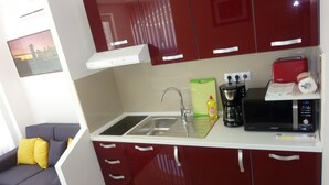 A compact kitchen with a sink, a coffee maker, and a microwave. - Apartment With View (Rab)