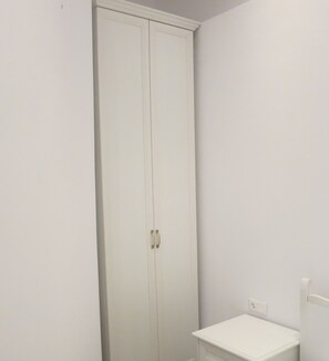 A white wardrobe with two doors and a small bedside table with drawers. - Room-andoni's House in Pitrofos Andros i (Andros)
