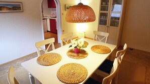A dining area with a white table, woven placemats, and chairs with blue cushions. - Living Above The Roofs Of Cochem (Cochem)