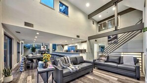 A spacious living area with a sofa, coffee table, and a staircase.