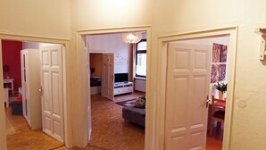 A hallway with white doors leading to various rooms, a wooden floor, and a red wall in the background. - Living in the Historic Cochem Old Town (Cochem)