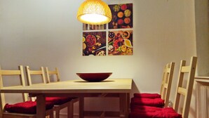 A dining table with a bowl, wooden chairs, red cushions, and a hanging light fixture. - Living in the Historic Cochem Old Town (Cochem)