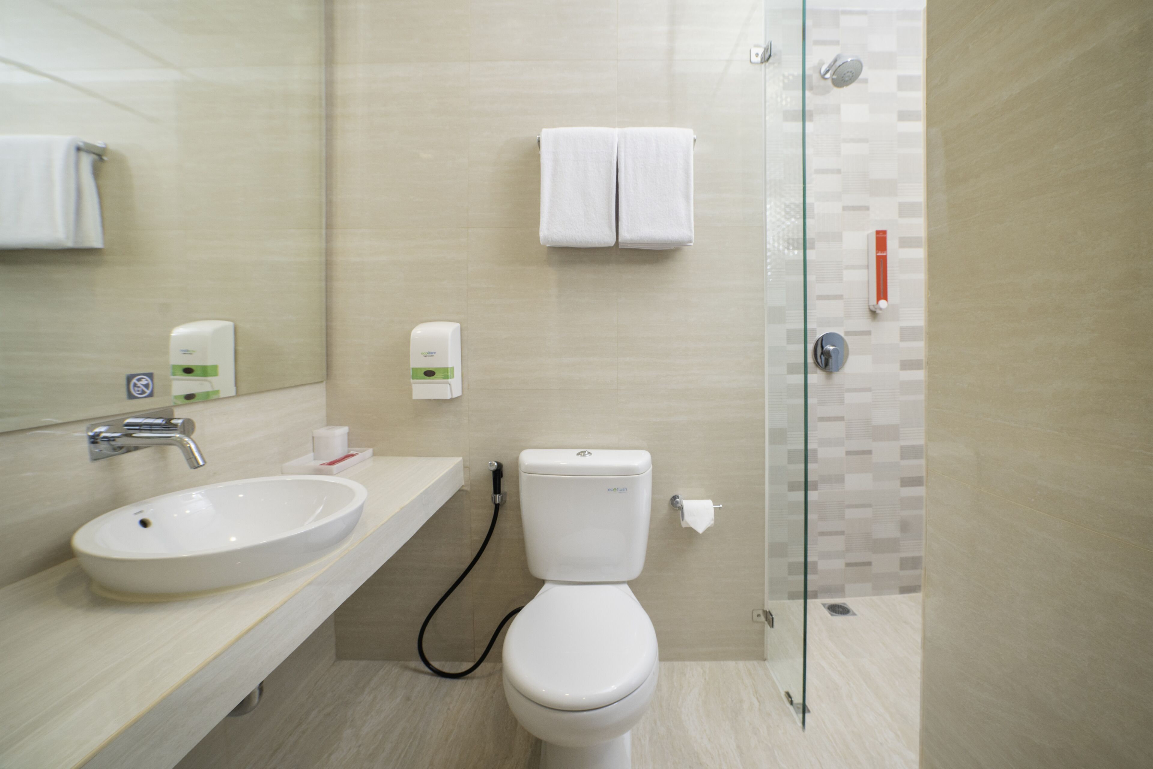 A modern bathroom with a sink, toilet, and glass shower enclosure.