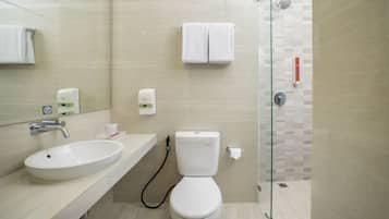 A modern bathroom with a sink, toilet, and glass shower enclosure.