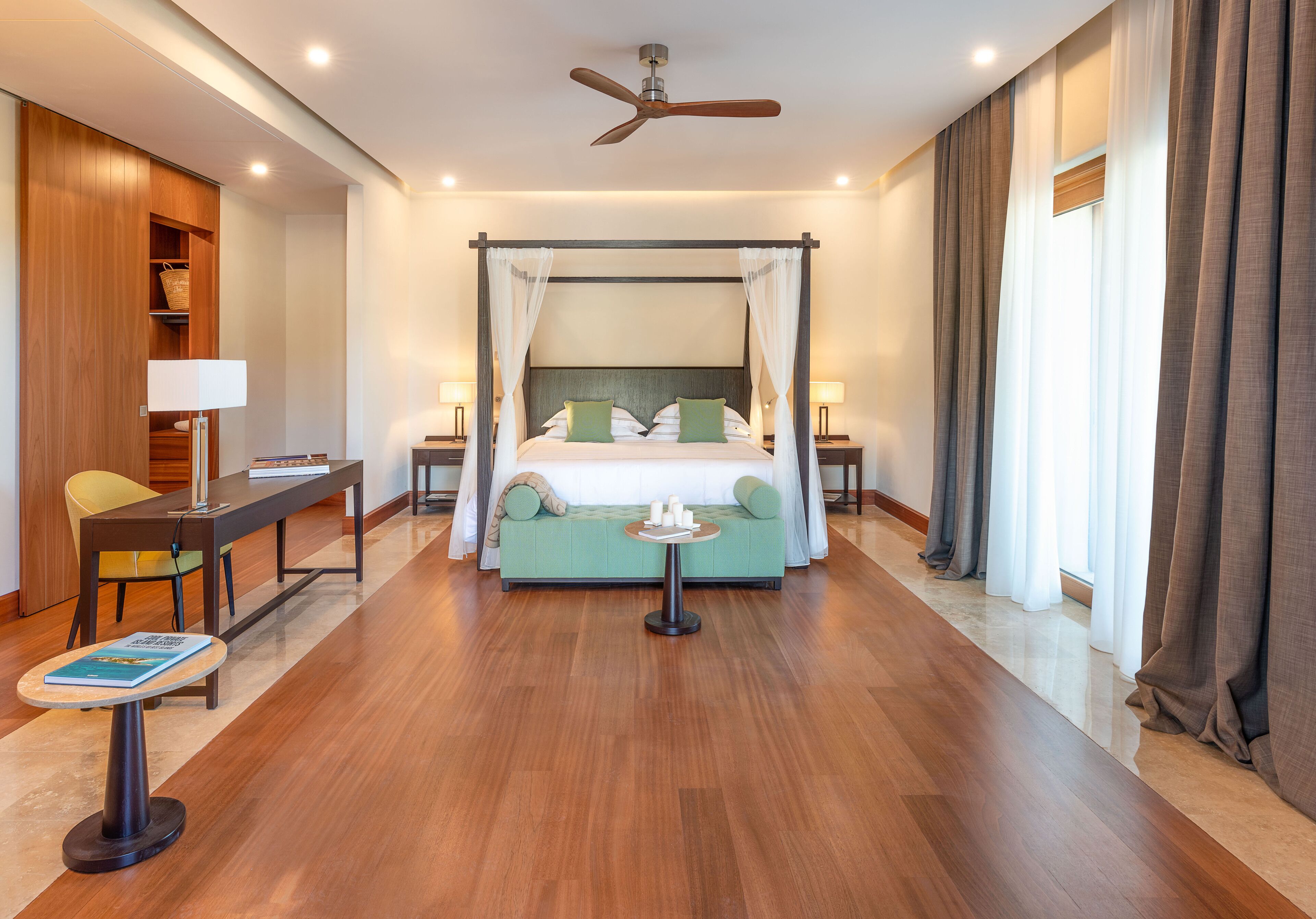 A spacious hotel room with a large bed, a desk, and a reading area.
