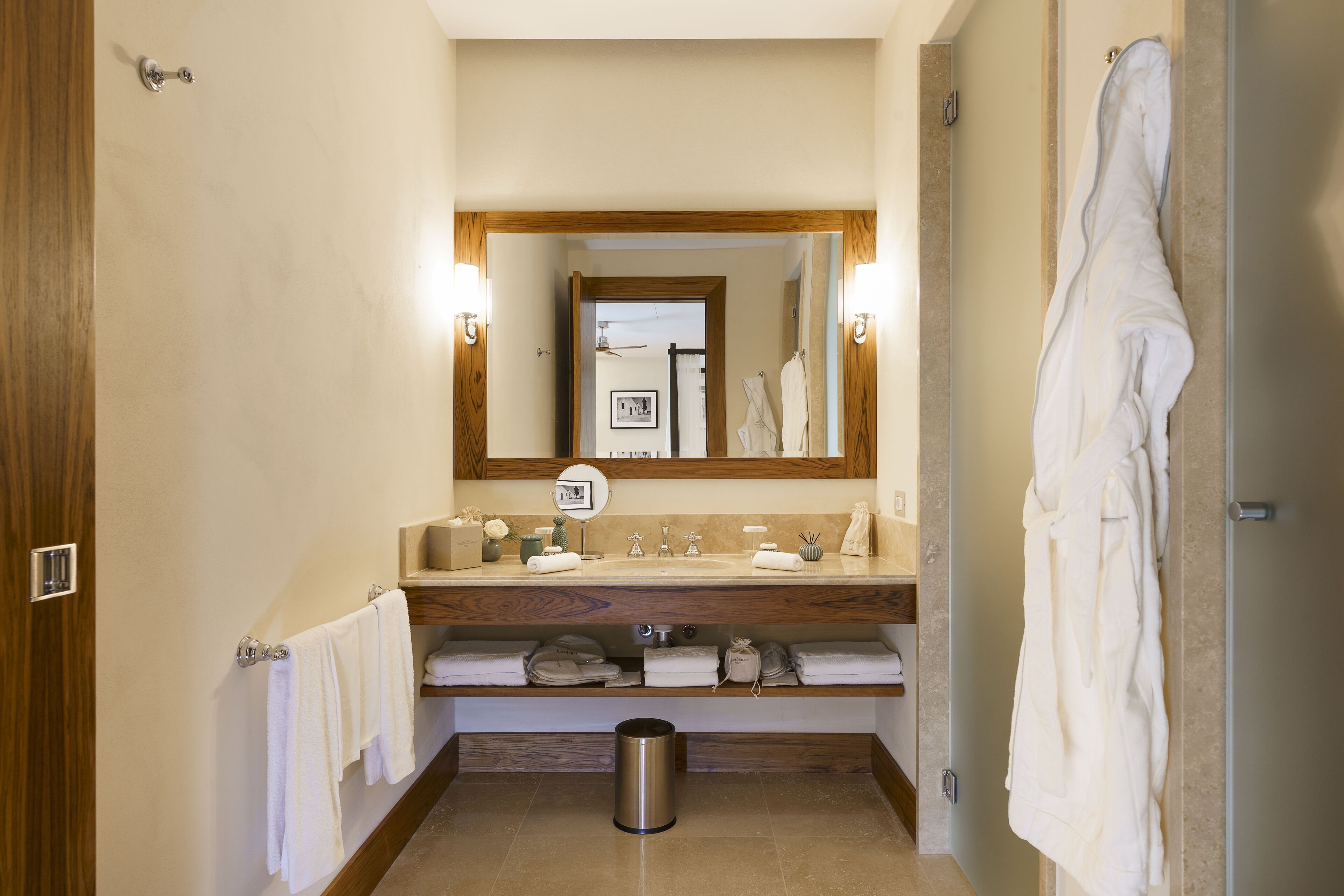 A bathroom with a wooden vanity, a mirror, and a towel rack.