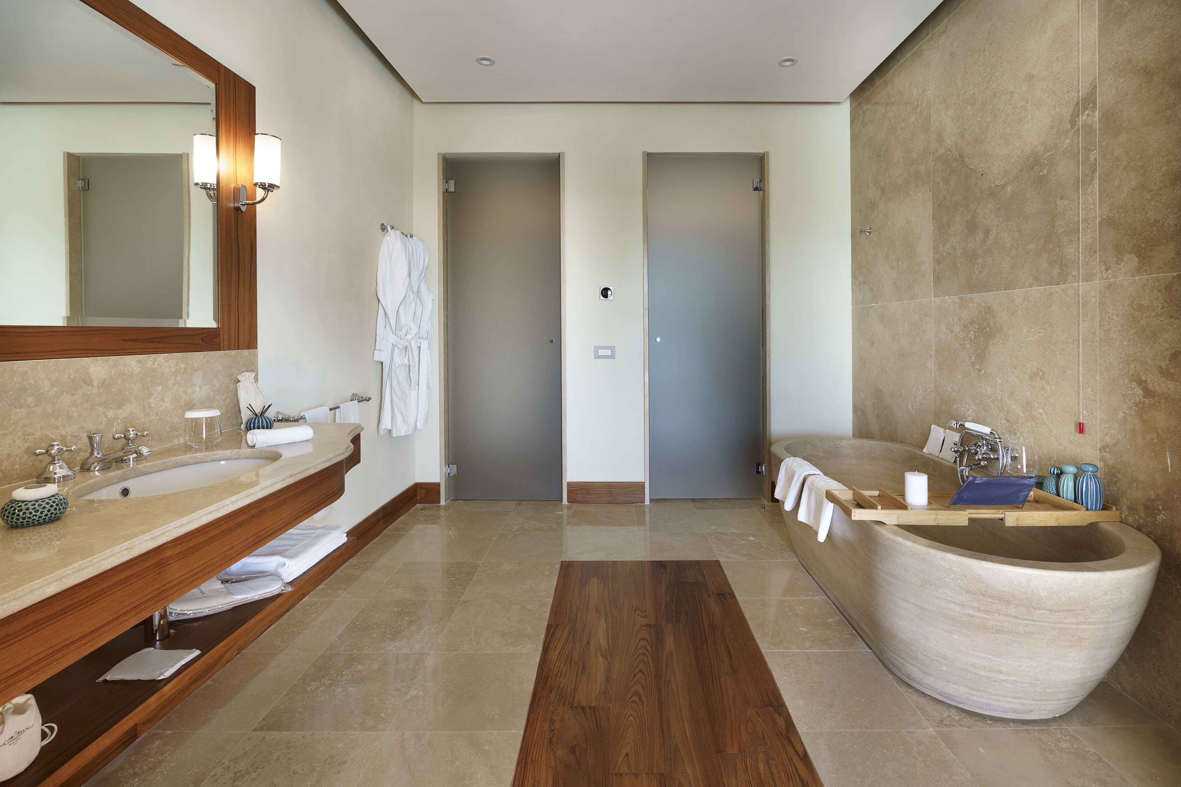 A modern bathroom with a large bathtub, two sinks, and a mirror.