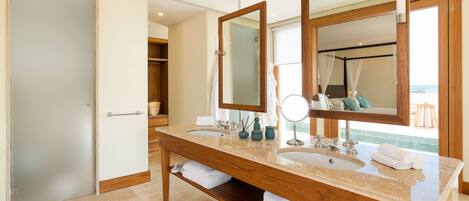A spacious bathroom with a large wooden vanity, dual sinks, and a large mirror.