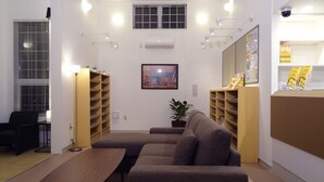 Ein modernes Wohnzimmer mit einer Couch, einem Esstisch und fest eingebauten Regalen.