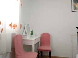 A room with a white desk, a mirror, a pink chair, and a small plant. - Room-stay in the Center of Zadar at Peni (Zadar)