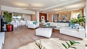 A spacious living area with a white sofa set, a coffee table, and a dining area with chairs. - Villa Montericco (Rovinj)