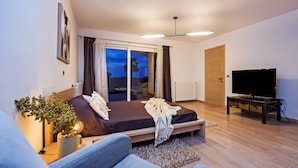 A bedroom with a bed, a television, and a view of the outdoors. - Villa Montericco (Rovinj)