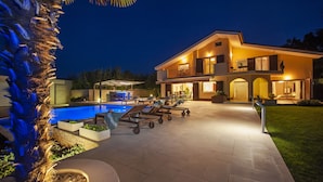 A modern two-story house with a swimming pool, outdoor seating, and a well-lit patio area. - Villa Montericco (Rovinj)