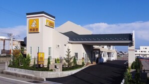 A hotel entrance with a covered walkway, signage indicating amenities, and a clear sky. - Family Lodge Hatagoya Kobe Suma (Kobe)