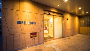 A hotel entrance with a modern design, featuring a prominent 'Super Hotel' sign. - Super Hotel Hirosaki (Hirosaki)