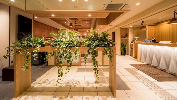 A hotel lobby with a reception desk, wooden reception area, and a tiled floor. - Super Hotel Hirosaki (Hirosaki)