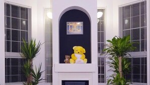 A living room with a fireplace, two potted plants, and a sofa. - Family Lodge Hatagoya Meihan Nagashima (Kuwana)