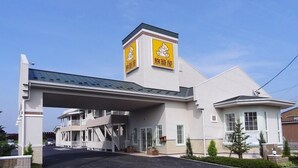 A hotel with a covered entrance, a prominent sign with a cartoon character, and a two-story structure with a flat roof. - Family Lodge Hatagoya Meihan Nagashima (Kuwana)