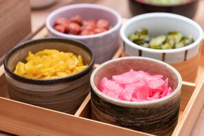 Una bandeja de madera con cuatro cuencos de cerámica que contienen distintos alimentos.