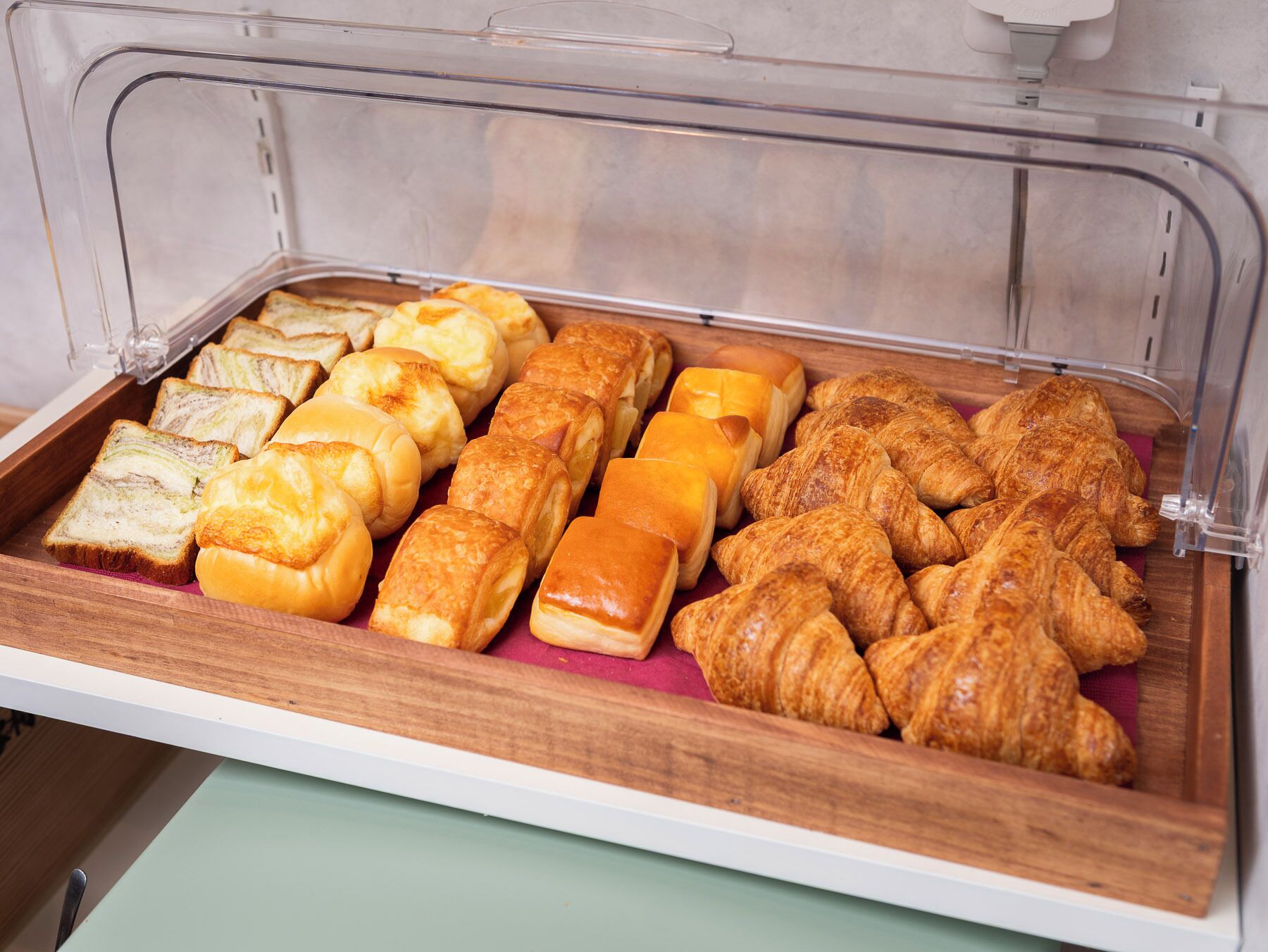 A breakfast buffet with various pastries and bread.